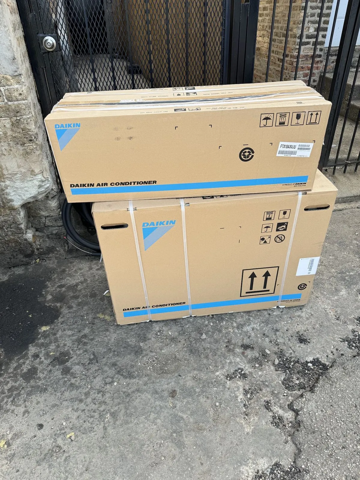 Two boxed ductless units standing in a Chicago alley on the morning of an installation.