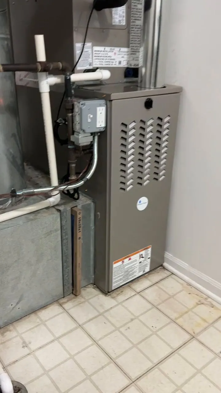 A newly installed gas furnace in a tiled utility closet.