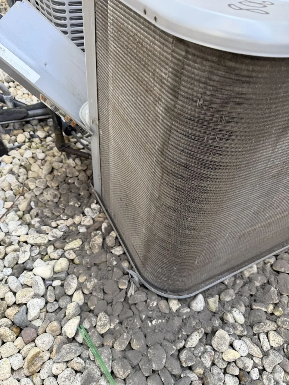 Close-up of the same condenser coil corner after cleaning, with straight clean fins.